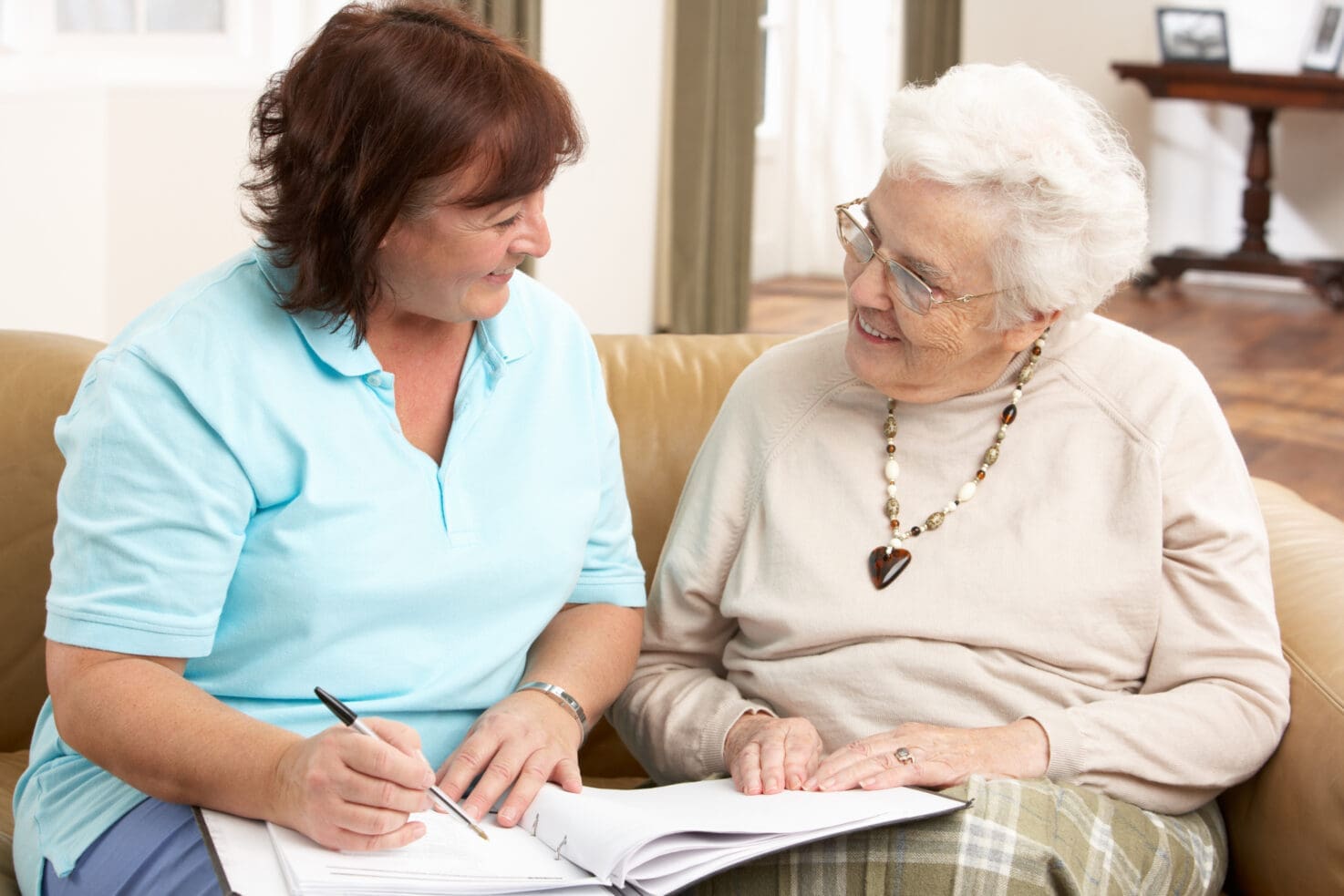 Senior Woman In Discussion With Caregiver At Home